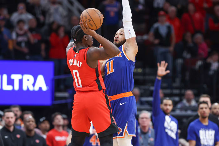 Knicks guard Jalen Brunson (11) fouls Houston Rockets guard Aaron Holiday (0) on a play in the final moments of the fourth quarter at Toyota Center.